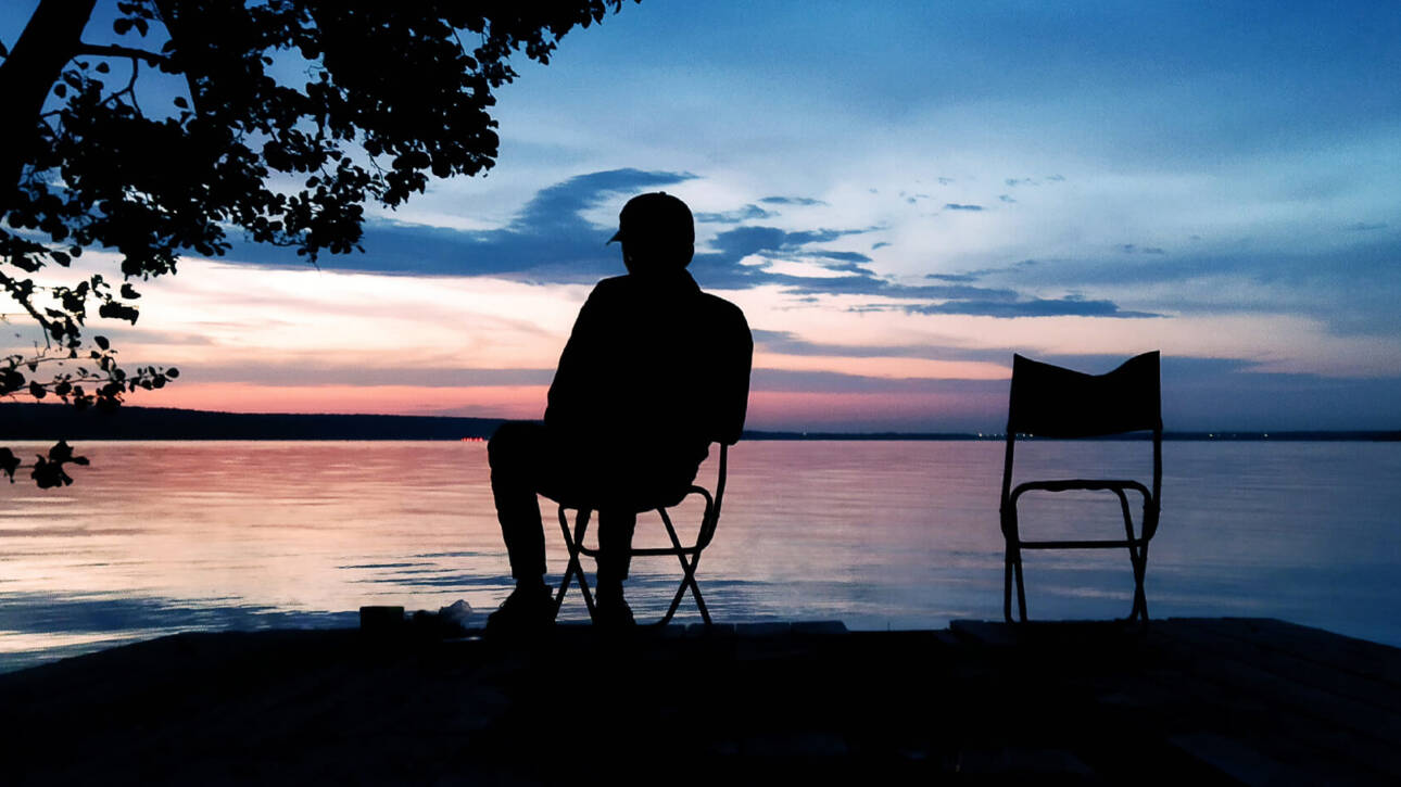 Building an Evening Routine for Peak Performance Preservation - a silhouette of a man by a lake