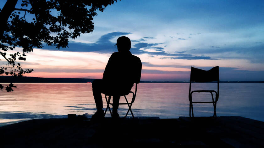 Building an Evening Routine for Peak Performance Preservation - a silhouette of a man by a lake