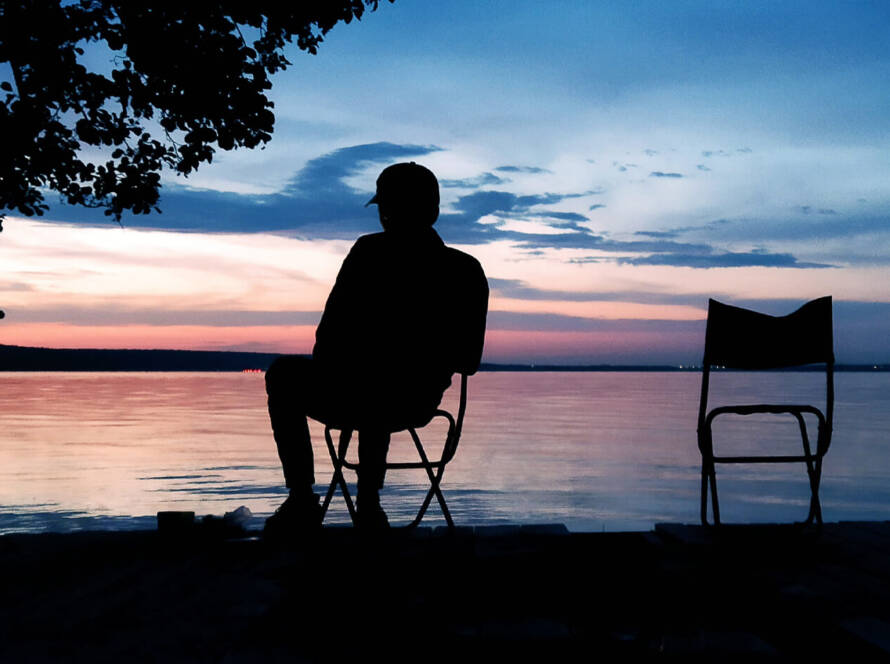 Building an Evening Routine for Peak Performance Preservation - a silhouette of a man by a lake